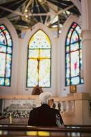 Senior mulher Rezar Eu a Igreja fé dentro religioso. foto