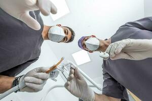 dentista e assistente pronto para tratar paciente foto