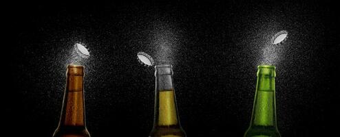fechar-se foto do a três Cerveja garrafa espirrando Cerveja gotas em uma Preto fundo. Cerveja boné vôo em topo do a garrafa