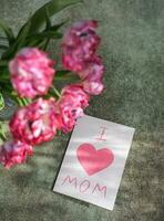 uma ramalhete do tulipas e uma cartão com a texto Eu amor mãe. mãe dia conceito foto