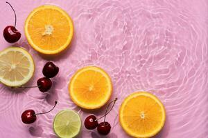 laranjas e cerejas dentro Rosa água fundo com concêntrico círculos e ondulações. refrescante verão conceito, cópia de espaço foto