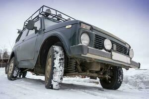 a velho brutal clássico 4x4 suv em uma Nevado inverno estrada foto