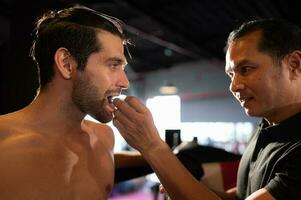 a boxer devo vestem uma dente colarinho antes a luta para evita a risco do prejuízo a partir de dentes confronto quando socado dentro a queixo ou face, muay tailandês, tailandês marcial artes. foto