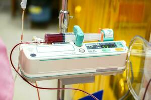 sangue dentro seringa bomba máquina transferindo sangue para uma doente recém-nascido bebê dentro uma hospital. foto