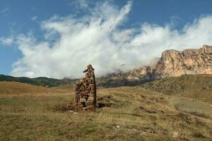 a antigo pedra ídolo em a fundo do enevoado montanhas. lápides fez do pedra. stur-digora região. norte ossétia. foto