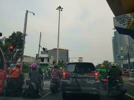 bekasi, Indonésia dentro marcha 2019. de várias motocicletas e carros parado às a vermelho luz dentro leste Bekasi debaixo a viaduto para narogong. foto