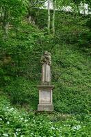 velho pedra figura do santo antônio profundo dentro a floresta em a Beira do uma Preto floresta caminhada trilha. Alemanha foto