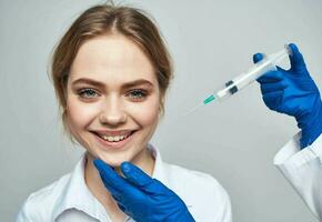 fêmea paciente sorridente e uma seringa dentro a mãos do a médico botox injeção foto