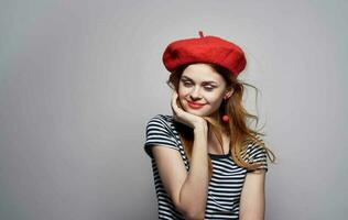 alegre mulher listrado camiseta com vermelho chapéu sorrir charme modelo foto