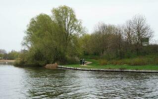 baixo ângulo Visão do vontade lago parque com local e turista público desfrutando a beleza do lago e parque de caminhando por aí com seus famílias. cenas estava capturado em 09 de abril de 2023 às Milton keynes Reino Unido foto