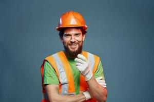 uma homem dentro uma trabalhos uniforme é uma construção engenheiro. indústria profissional laranja Difícil chapéu foto