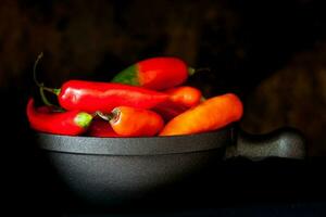 vermelho quente Pimenta pimentas em Preto fundo foto