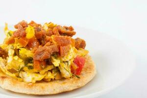 tradicional colombiano arepa coberto com frango seio e carne de porco casca foto