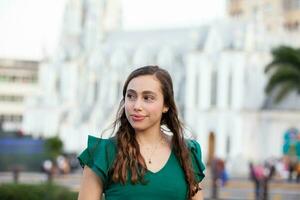 lindo turista menina às a ortiz ponte com la ermita Igreja em fundo dentro a cidade do cali dentro Colômbia foto