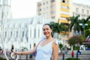 lindo turista mulher às a ortiz ponte com la ermita Igreja em fundo dentro a cidade do cali dentro Colômbia foto