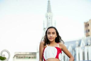 lindo turista menina às a ortiz ponte com la ermita Igreja em fundo dentro a cidade do cali dentro Colômbia foto