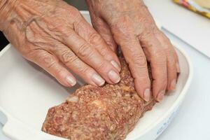 preparação do uma cozido ovo e legumes recheado Rolo de carne coberto com bacon. carne lista foto