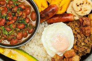 tradicional colombiano prato chamado banda paisa uma prato típica do Medellin este inclui carne, feijões, ovo e bananeira foto