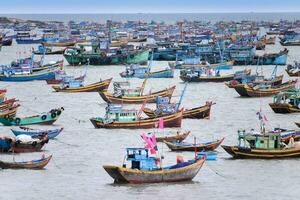 vietnamita pescaria Vila, mui bem, Vietnã, sudeste Ásia. panorama com mar e tradicional colorida pescaria barcos às muine. popular ponto de referência e turista destino do Vietnã. foto