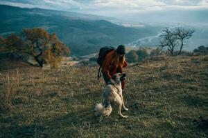 mulheres caminhantes Próximo para cachorro andar montanhas outono foto