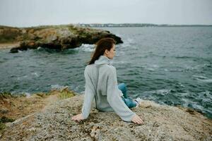 mulher blusas nublado mar admirando natureza estilo de vida foto