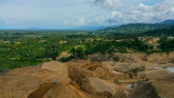 aéreo Visão do trabalhos do caminhões e a escavadora dentro a aberto Cova em ouro mineração. central sulawesi, Indonésia, marcha 3, 2022 foto