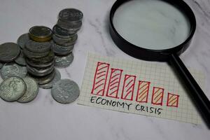 economia crise e moedas escrever em pegajoso notas isolado em escritório escrivaninha foto