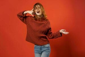 alegre mulher dentro vermelho suéter posando moda estúdio isolado fundo foto