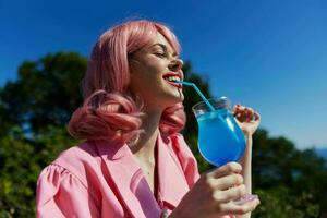 glamouroso mulher com Rosa cabelo verão coquetel refrescante beber relaxamento conceito foto