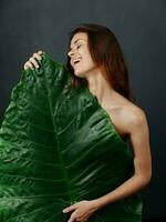 alegre bonita mulher cobre nu corpo com verde folha foto