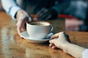 a chefe de cozinha serve a cliente uma copo do café com uma pires em a mesa e uma restaurante beber foto