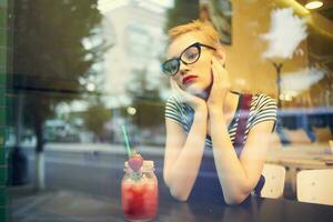 mulher com óculos sentado dentro uma restaurante coquetel período de férias solidão foto