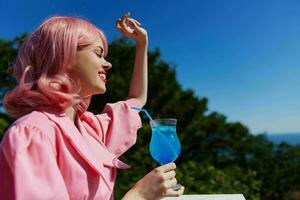 Deleitado jovem menina com Rosa cabelo verão coquetel refrescante beber verão dia foto