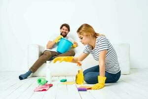 homem e mulher lavando suprimentos limpeza tarefas domésticas foto