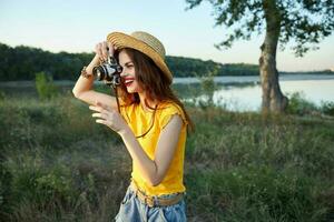 alegre mulher fotógrafo parece para dentro a Câmera lente passatempo estilo de vida natureza foto