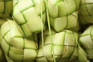 ketupat ásia arroz bolinho de massa. ketupat é uma natural arroz invólucro fez a partir de jovem coco folhas para cozinhando arroz durante eid Mubarak eid ul fitr foto