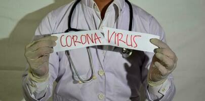 uma médico desgasta uma saúde mascarar e uma cutucar papel corona vírus isolado em branco fundo. foto