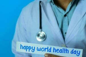 médico segurando uma cartão com texto feliz mundo saúde dia. médico e cuidados de saúde conceito. foto