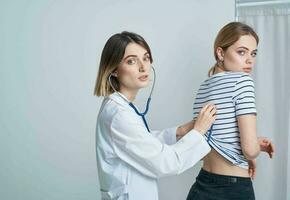 médico mulher dentro médico vestido com estetoscópio escuta para pacientes coração foto