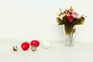feriado do a ressurreição do Cristo Páscoa vermelho ovos e uma ramalhete do flores dentro uma vaso foto