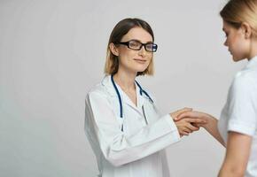 profissional médico mulher e paciente mexe mãos em uma luz fundo foto