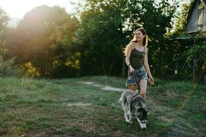 mulher e dela rouco cachorro alegremente corrida através a Relva dentro natureza dentro a parque sorrir com dentes outono andar com bicho de estimação, viajando com uma cachorro amigo foto
