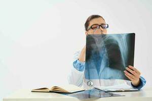 médico senta às a mesa raio X cenário radiologista pesquisa foto