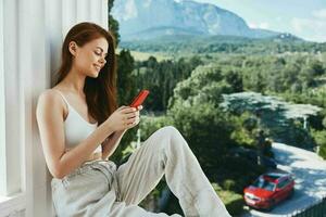 alegre mulher com uma vermelho telefone terraço ao ar livre luxo panorama lazer inalterado foto