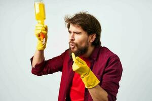 emocional homem vestindo borracha luvas detergente limpeza tarefas domésticas cortada Visão foto