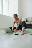 freelance mulher com computador portátil e telefone trabalho a partir de casa sentado em a chão dentro dela casa roupas com uma curto corte de cabelo, livre cópia de espaço foto