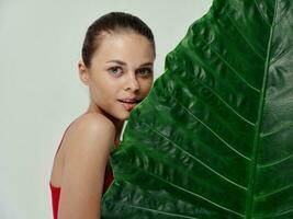 mulher com verde folha Compreendo em luz fundo cortada Visão foto