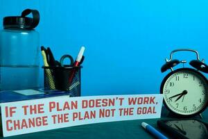 E se a plano não trabalhar, mudança a plano não a objetivo planejamento em fundo do trabalhando mesa com escritório suprimentos. o negócio conceito planejamento em azul fundo foto