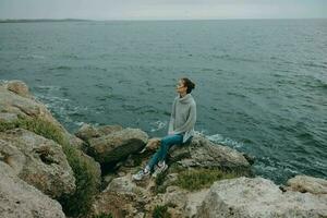 retrato do uma mulher natureza pedras costa panorama oceano relaxamento conceito foto