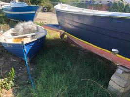 barcos de pesca vazios apodrecendo em um campo gramado foto